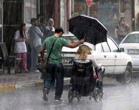 Kindness-Man-holding-umbrella-in-rain-woman-in-wheelchair