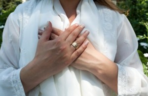 Hands-over-heart-woman-white-clothes